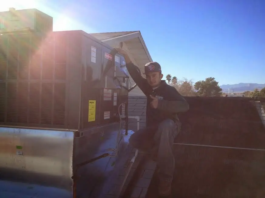 HVAC technician performing Boiler Repair on a rooftop unit in Roanoke